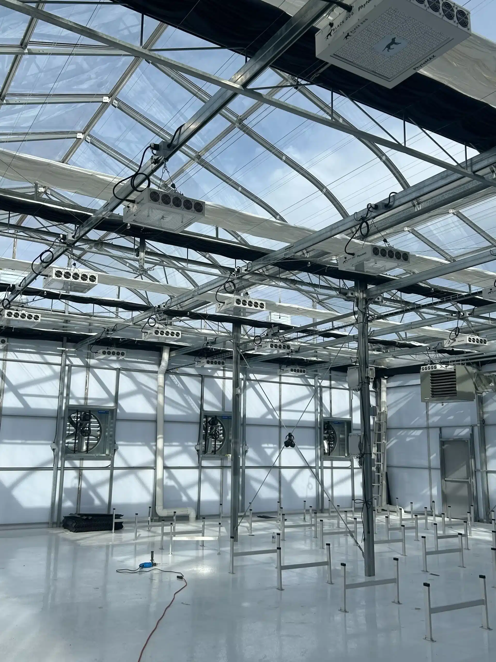 Interior of a modern greenhouse with transparent roofing and advanced lighting and irrigation systems.